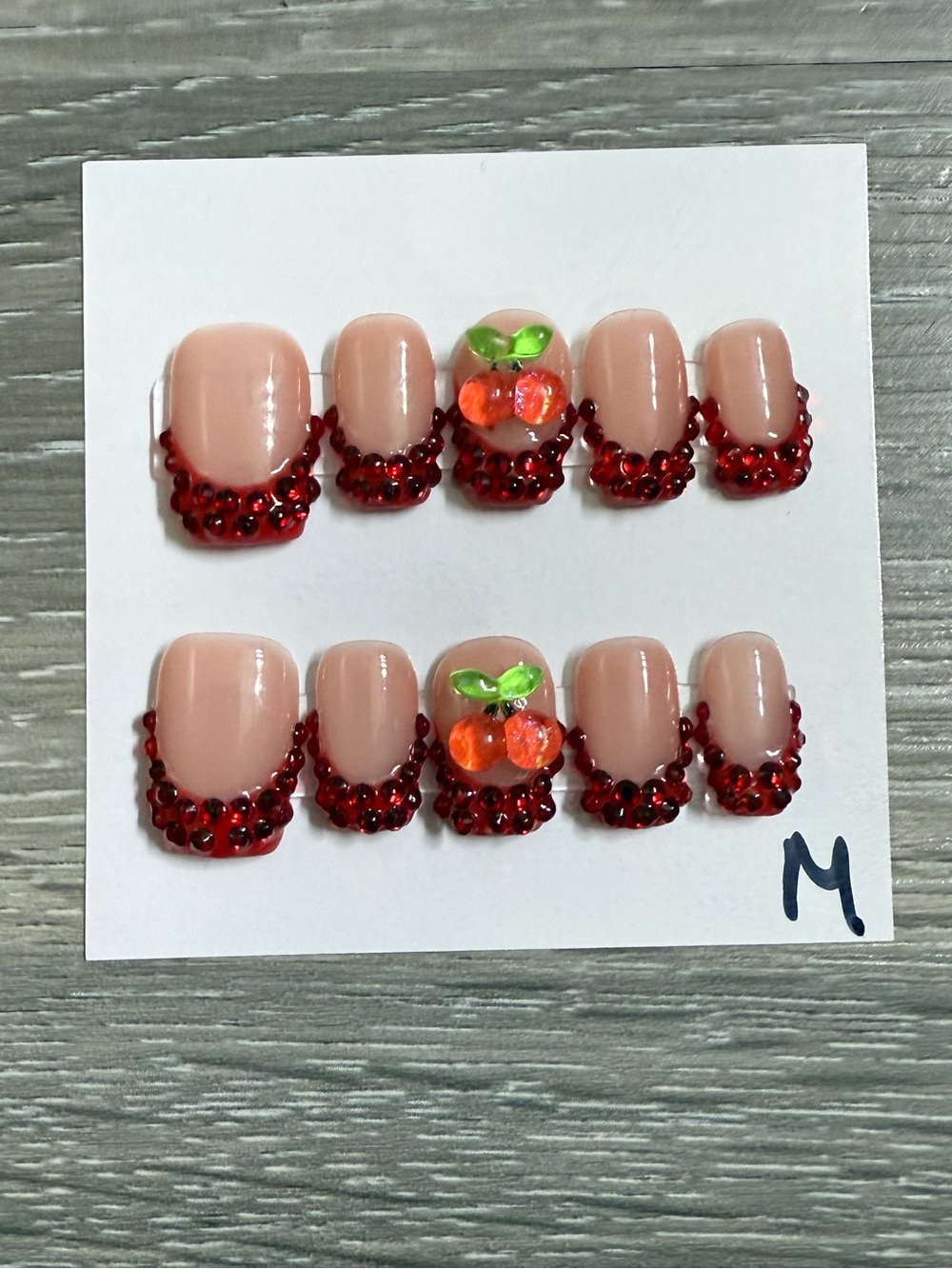 Nude Almond Press-On Nails with Red Rhinestone Tips and Red Gem Accent